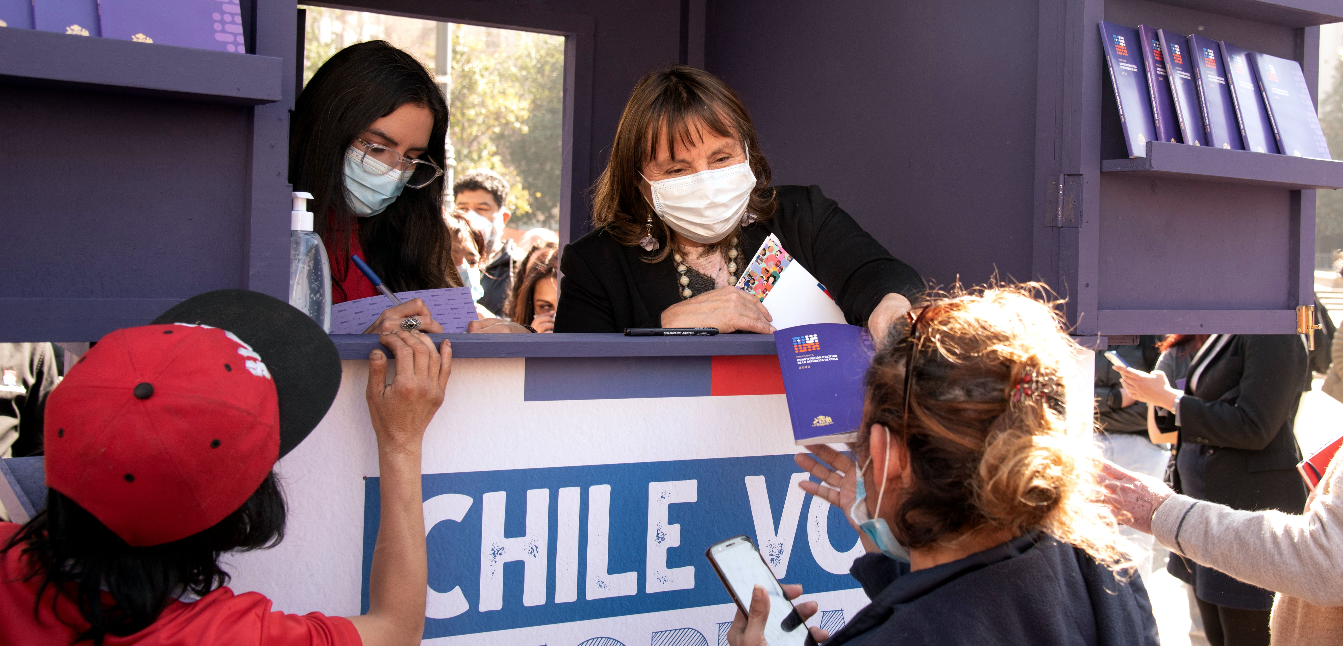 Este miércoles se instaló un punto de distribución permanente en la Plaza de la Constitución en la comuna de Santiago, donde las personas podrán retirar la propuesta de nueva Constitución de manera gratuita.